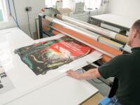 Printed artwork being prepped for face-bonding to acrylic